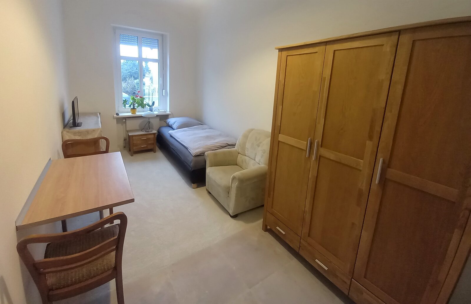 Wohnraum mit Schreibtisch und großem Kleiderschrank